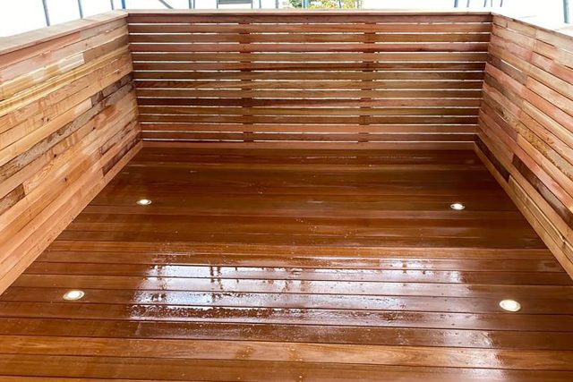 A luxurious roof terrace design in Chiswick featuring natural cedar decking and elegant double French wooden doors.