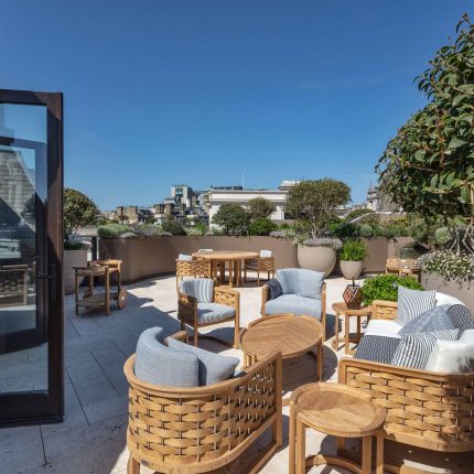 Refurbished apartment balcony with glass balustrades and outdoor seating