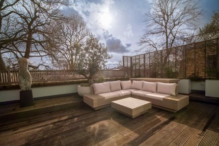 Environmentally friendly roof terrace design in Kensington showcasing durable wood decking and biodiversity-promoting greenery.