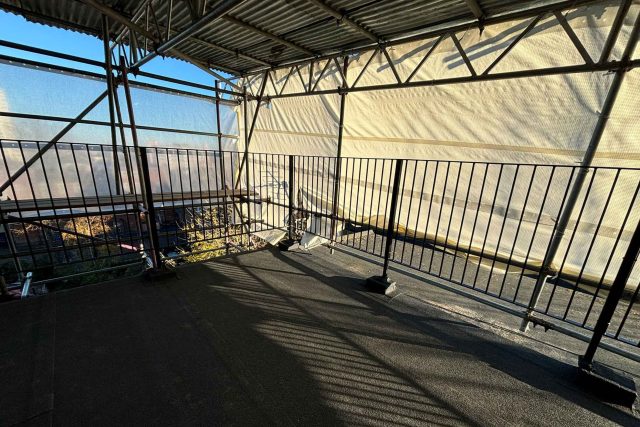 Newly installed weather-proof felt roof system surrounded by safety scaffolding during a comprehensive Esher renovation.