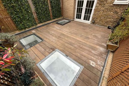 Bespoke glass skylights integrated seamlessly into restored wooden decking on a luxury residential terrace in Surrey.