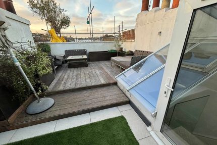 Bespoke multi-level wood decking and integrated seating transforming a residential roof terrace in Pimlico.