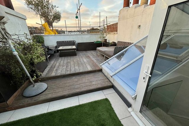 High-end timber decking meticulously fitted around a structural glass atrium to maximise light on a domestic London property.