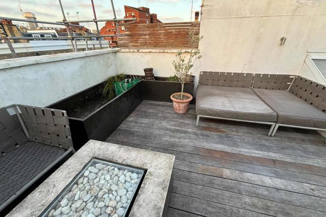 Weathered timber decking and bespoke metal planters completing a premium residential flat roofing London conversion in Esher.