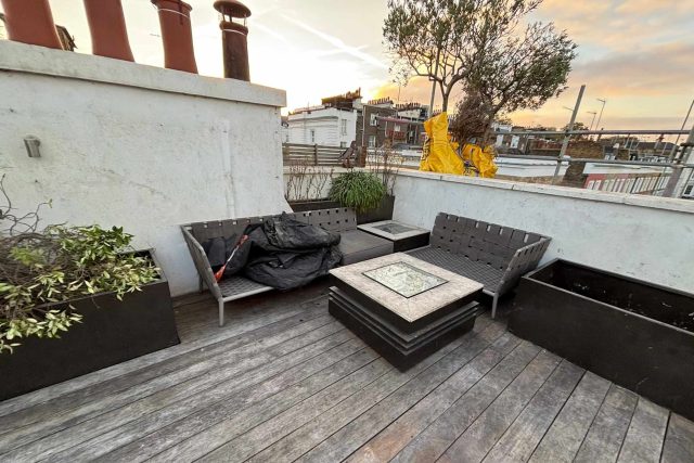 Smooth timber decking providing a robust foundation for luxury outdoor furnishings on a modern flat roof conversion.