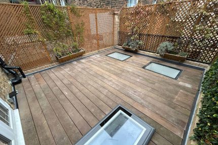 Natural wooden decking positioned alongside structural skylights during a residential roof terrace refurbishment in Weybridge.