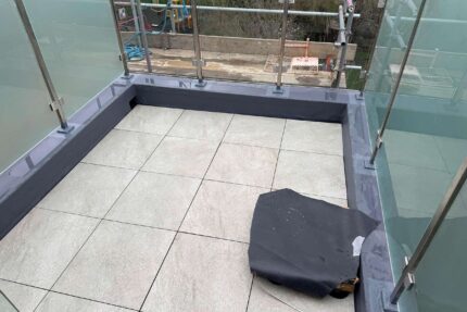 Installation of a modern single-ply flat roofing system during a comprehensive roof terrace refurbishment.