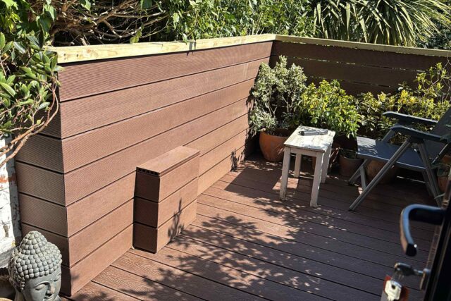High-end eco-friendly composite decking and secure timber railings installed by specialist flat roofing London contractors.