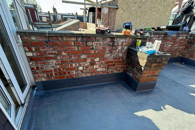 Resilient EPDM membrane and secure coping stones completing a thorough flat roofing London residential refurbishment.