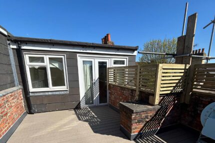 Beautifully refurbished flat roof terrace displaying slip-resistant composite decking and an elegant privacy screen.