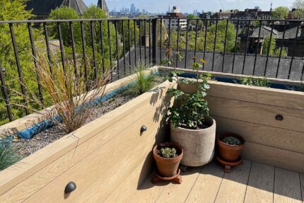 Commercial-grade Millboard decking and bespoke integrated planters constructed for a corporate roof garden by a specialist roofer London.