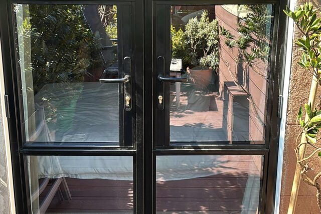 Highly insulated aluminium French doors providing elegant and secure access to a newly refurbished flat roofing London domestic terrace.