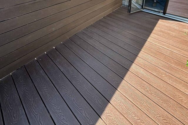 Close-up detail of weather-proof wood grain composite decking installed during a luxury London roofing upgrade.