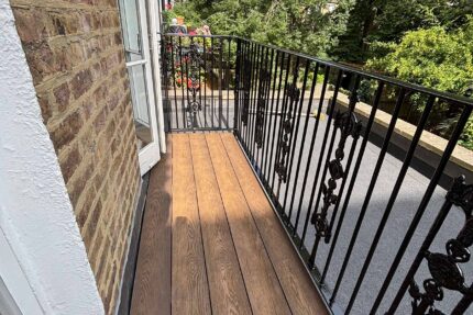 Weather-resistant composite decking seamlessly integrated with safety railings for a luxury flat roofing London residential refurbishment.
