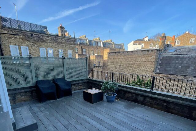 Eco-friendly grey Millboard decking and a custom slatted timber privacy screen installed on a residential Maida Vale terrace by our specialist flat roofer London team, delivering a weather-resistant outdoor sanctuary.