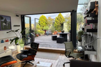 Seamless lifestyle upgrade featuring premium decking leading from bi-fold doors on a residential Shoreditch, London flat roof conversion.