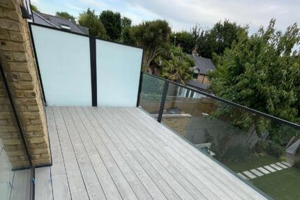 Laying enhanced grain Millboard decking on support pads for a new roof terrace.