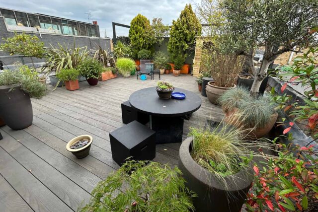 Premium grey composite decking supporting a luxury al-fresco dining table in this bespoke Shoreditch, London flat roof conversion.
