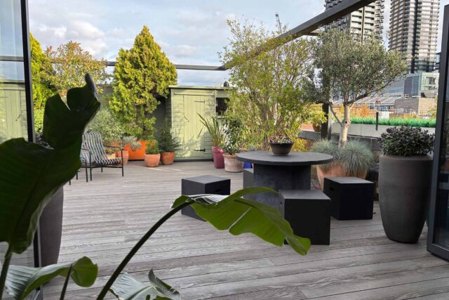 Contemporary grey decking providing a robust, weather-proof foundation for outdoor seating on a premium Shoreditch flat roof conversion.