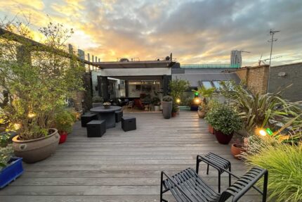 High-end flat roofing London installation showcasing bespoke horticultural planters and integrated seating areas on a durable composite deck.