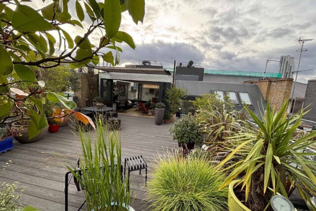 Beautifully crafted wooden decking integrated with modern bi-fold doors to elevate property value in this Shoreditch flat roof conversion.
