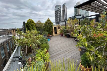 Structural flat roof conversion in Shoreditch by our specialist London roofing contractors, highlighting zero-rot wooden composite decking and catalogued planter restoration.